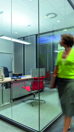 Žena nahlíží do soukromých kanceláří Audi osvětlených společností Philips Lighting.