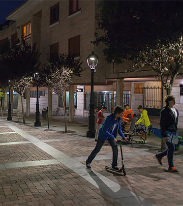 Lidé chodí po ulicích Palencia za noci pod osvětlením od společnosti Philips.