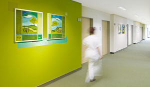 Sestra kráčí po chodbě v „zelené“ nemocnici. 