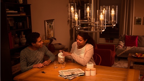 Dva lidé sedí doma na pohovce a užívají si kvalitní LED osvětlení
