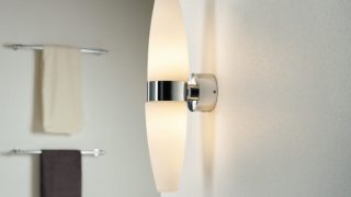 Moderní koupelna s elegantním nástěnným svítidlem LED, které osvětluje minimalistický dekor a dotváří atmosféru jako v lázních.